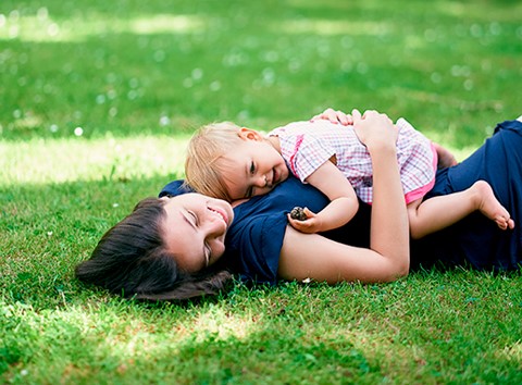 Femme avec son enfant allongés dans l'herbe